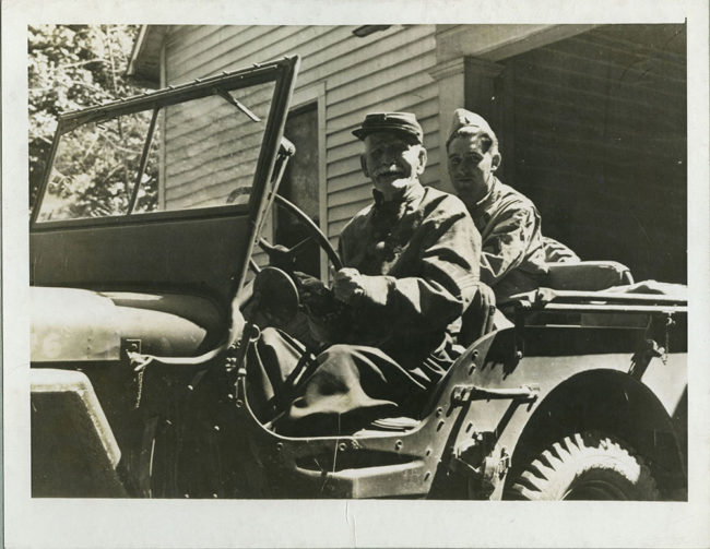 PHOTO CREDIT: PHOTO CAPTION: Franke E. Ross, age 99 of Murfreesboro, Tennessee, fought in the the infantry away back in Civil War days and now he would like to fight against the Nazis. He said, "If I could go back a few years, I'd be figting with you fellows." He proudly steers a Jeep in front of his home during the pause of a unit there while on the maneuvers of the Second Army in middle Tennessee.