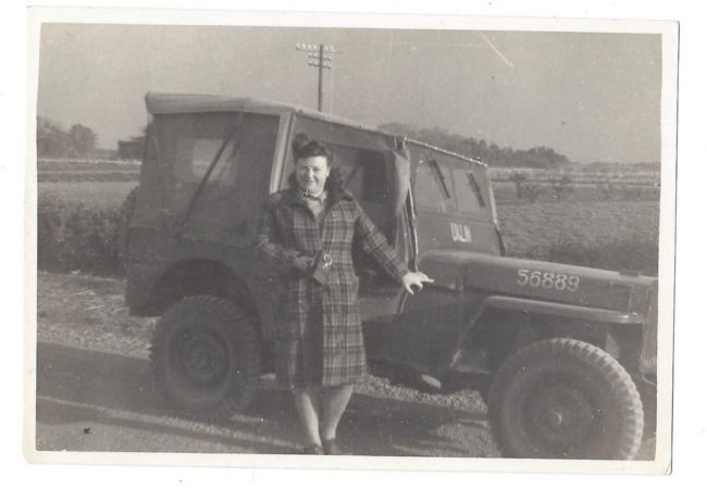 1945-lady-standing-next-to-jeep